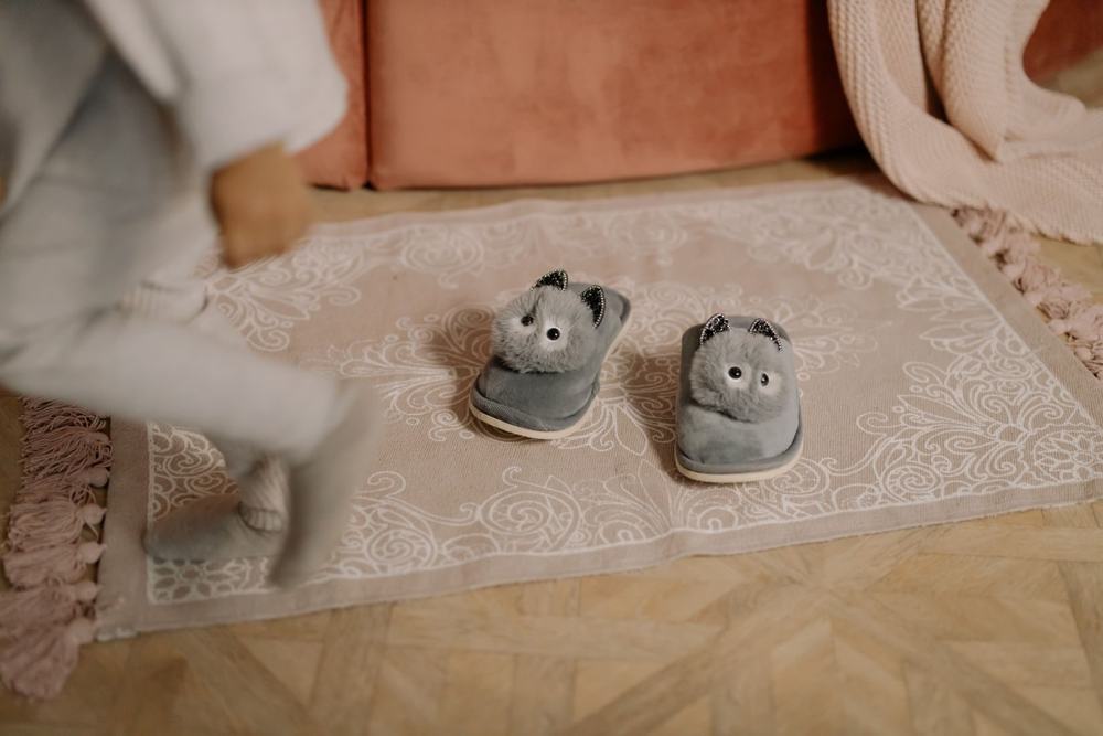 Dziecięce kapcie na dywanie przy łóżku